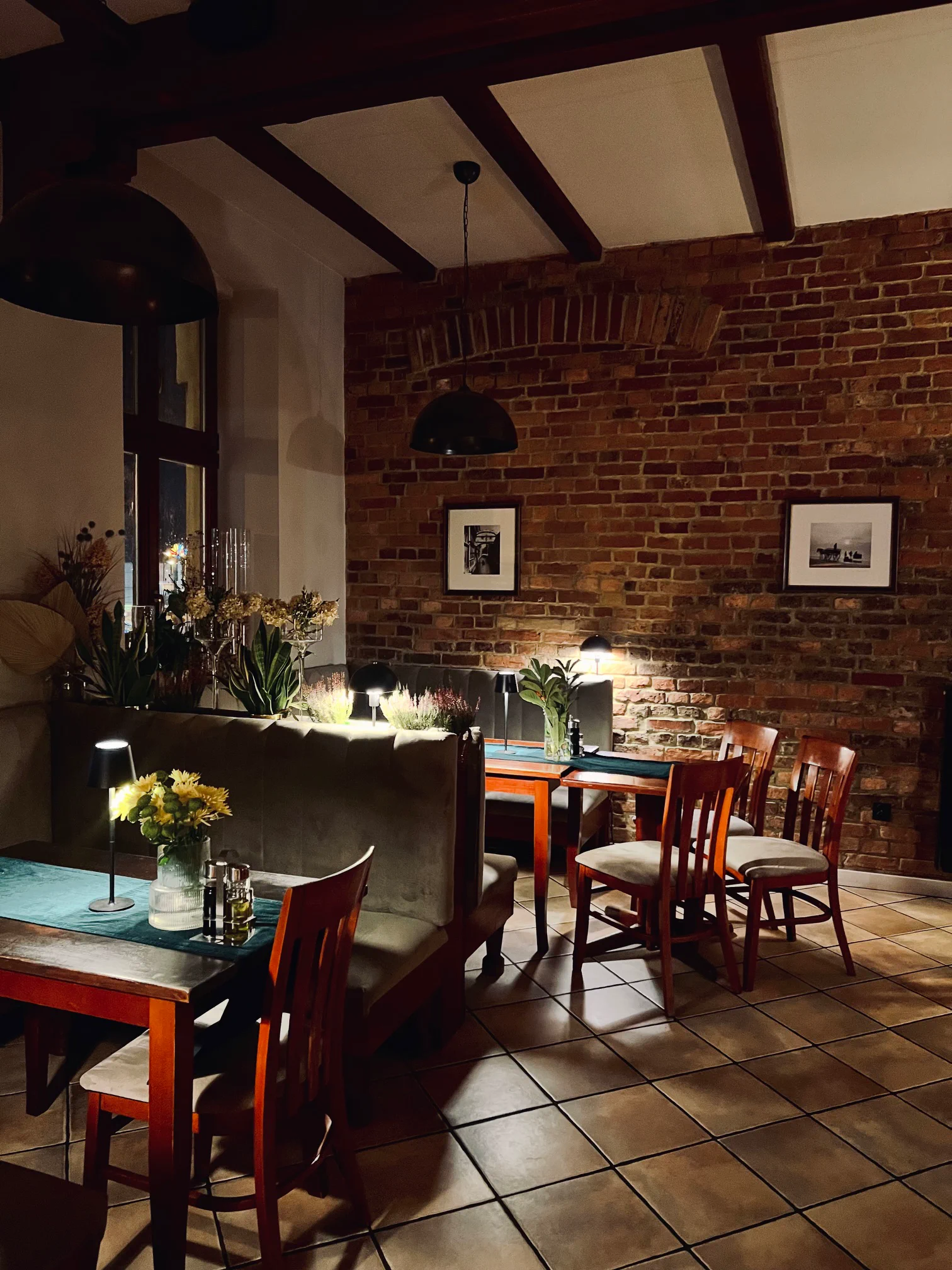 Tables in Sorrento’s brick dining room, lit by warm evening lights